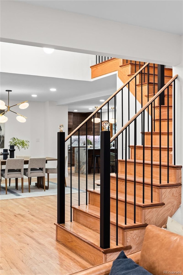 stairway featuring a notable chandelier and hardwood / wood-style flooring