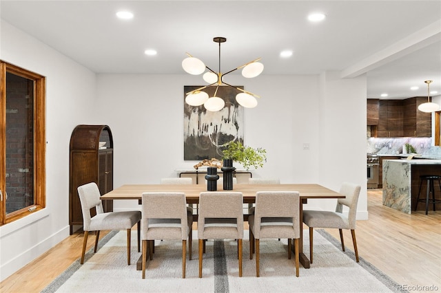 dining area featuring light hardwood / wood-style floors and an inviting chandelier