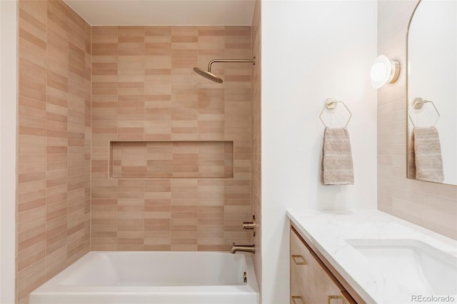 bathroom featuring vanity and tiled shower / bath