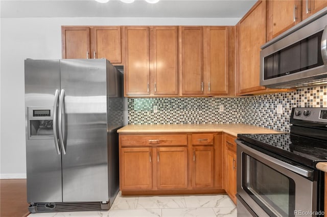 23456 E 5th Pl Unit 104, Aurora, CO 80018 - kitchen with stainless steel appliances, light countertops, light marble finish flooring, and backsplash
