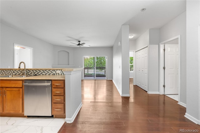 23456 E 5th Pl Unit 104, Aurora, CO 80018 - kitchen with stainless steel dishwasher, ceiling fan, brown cabinets, light countertops, and backsplash