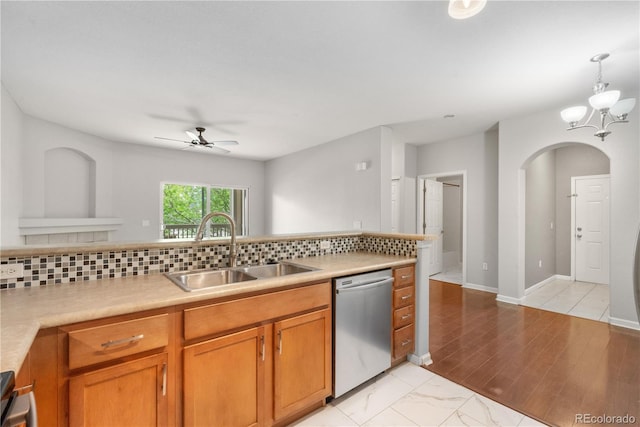 23456 E 5th Pl Unit 104, Aurora, CO 80018 - kitchen featuring dishwasher, arched walkways, a ceiling fan, decorative backsplash, and brown cabinetry