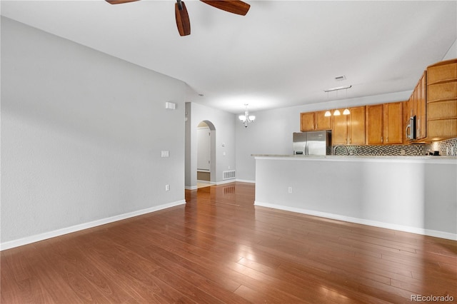 23456 E 5th Pl Unit 104, Aurora, CO 80018 - unfurnished living room with ceiling fan, arched walkways, wood finished floors, and a chandelier