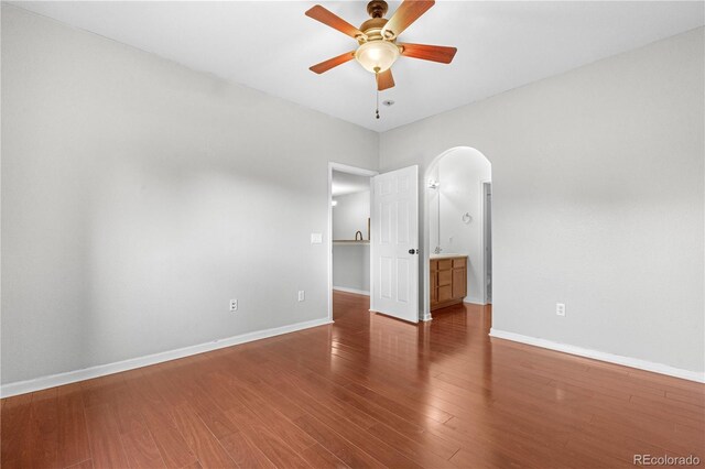 23456 E 5th Pl Unit 104, Aurora, CO 80018 - spare room featuring arched walkways, a ceiling fan, and wood finished floors