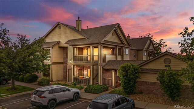 23456 E 5th Pl Unit 104, Aurora, CO 80018 - townhome / multi-family property featuring uncovered parking, brick siding, a balcony, covered porch, and a chimney