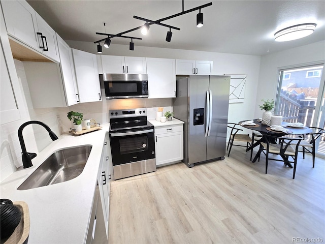 5721 W 92nd Ave Unit 66, Westminster, CO 80031 - kitchen featuring stainless steel appliances, a sink, light wood-style flooring, and tasteful backsplash