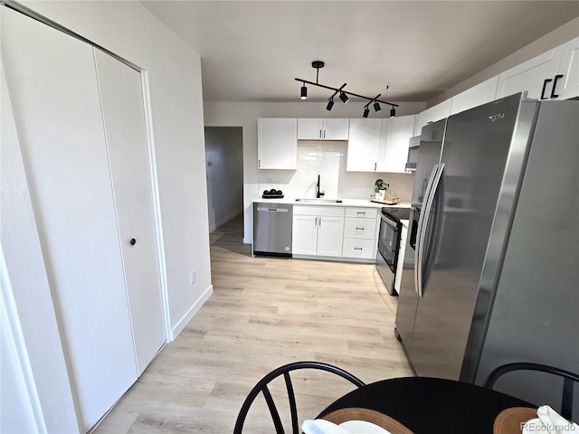 5721 W 92nd Ave Unit 66, Westminster, CO 80031 - kitchen with appliances with stainless steel finishes, light wood-style floors, white cabinetry, and a sink