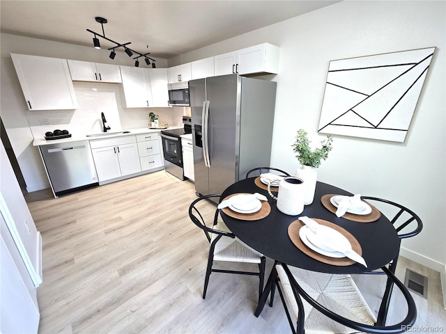 5721 W 92nd Ave Unit 66, Westminster, CO 80031 - kitchen featuring stainless steel appliances, a sink, light wood-type flooring, and white cabinets