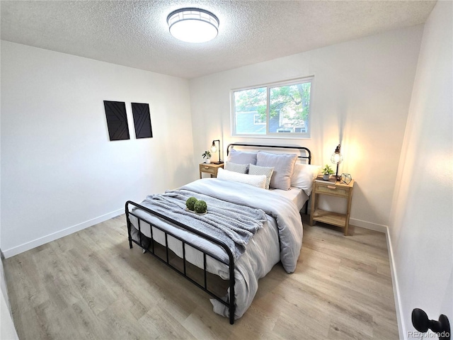 5721 W 92nd Ave Unit 66, Westminster, CO 80031 - bedroom featuring a textured ceiling, light wood-style floors, and baseboards