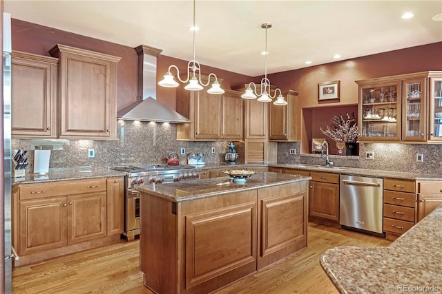 187 Fox Ridge Dr, Evergreen, CO 80439 - kitchen with appliances with stainless steel finishes, wall chimney range hood, decorative light fixtures, an inviting chandelier, and a kitchen island