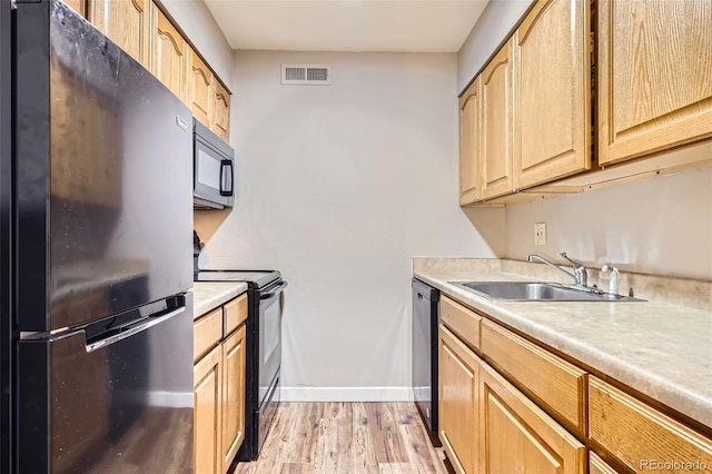 3653 S Sheridan Blvd Unit 16, Denver, CO 80235 - kitchen featuring black appliances, light countertops, light wood-style floors, and light brown cabinetry