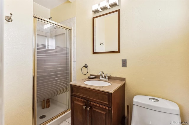 bathroom with vanity, toilet, and a shower with shower door