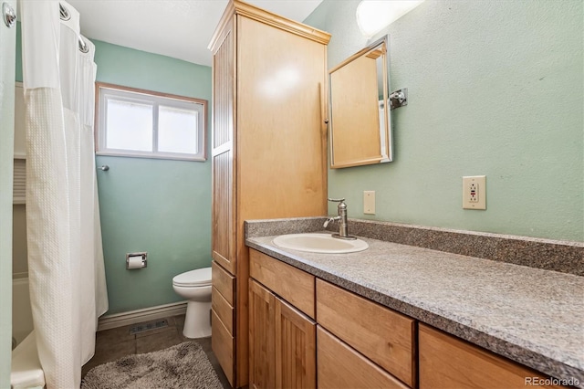 bathroom featuring vanity, tile patterned floors, and toilet