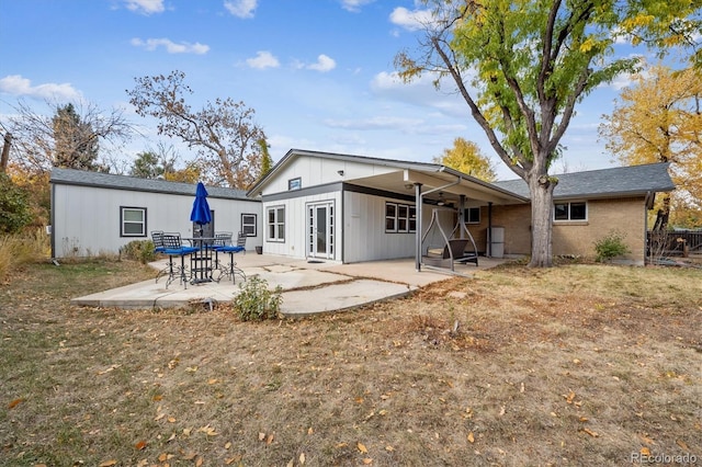 rear view of property featuring a patio and a yard