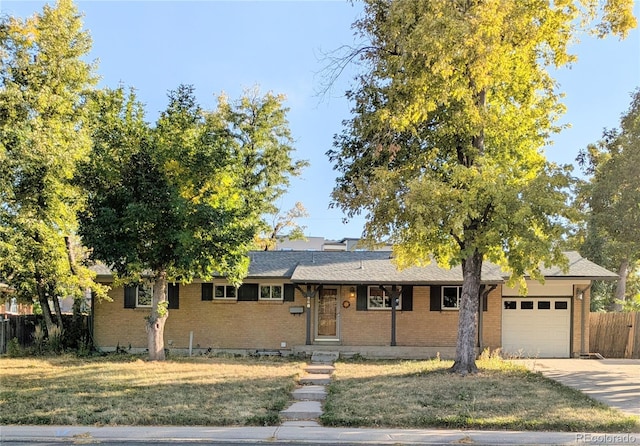 single story home featuring a garage and a front lawn