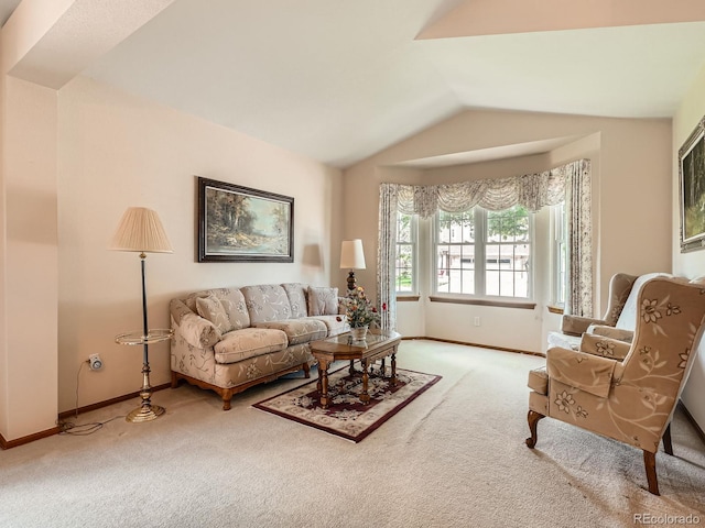 carpeted living area featuring baseboards and vaulted ceiling