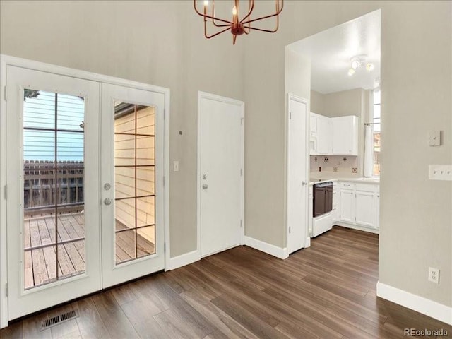 doorway to outside with french doors, plenty of natural light, baseboards, and a chandelier