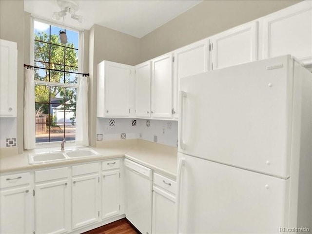 kitchen featuring white appliances, a sink, and white cabinets