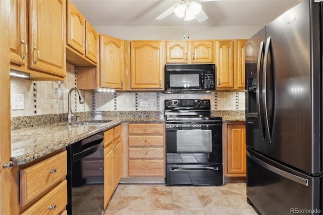 kitchen featuring ceiling fan, sink, tasteful backsplash, light stone counters, and black appliances