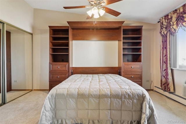 carpeted bedroom with ceiling fan, a closet, lofted ceiling, and a baseboard heating unit