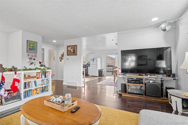 living room featuring wood-type flooring and a textured ceiling