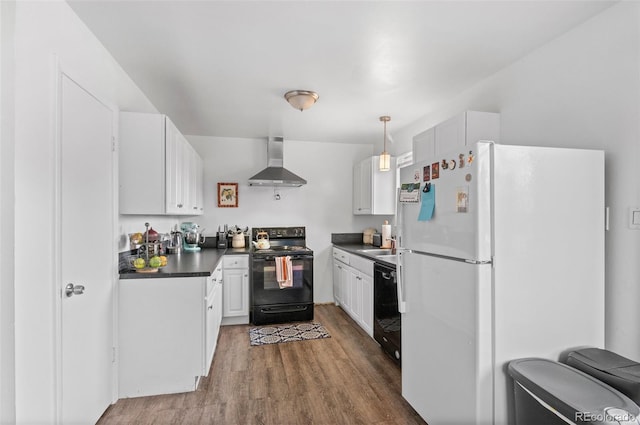 kitchen featuring hanging light fixtures, wall chimney range hood, white cabinets, black appliances, and hardwood / wood-style flooring