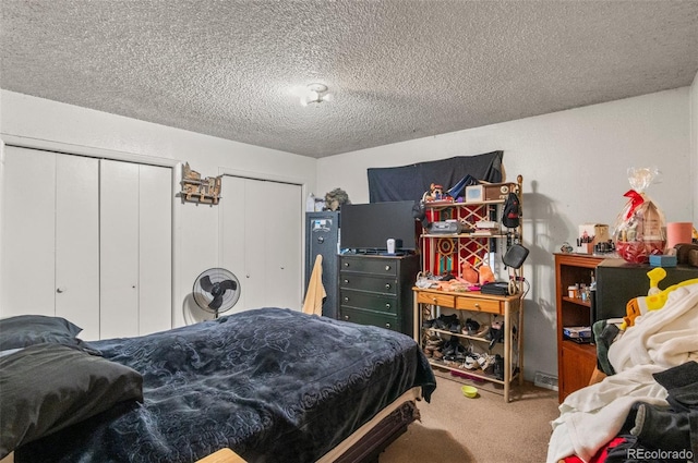 carpeted bedroom featuring a textured ceiling and two closets