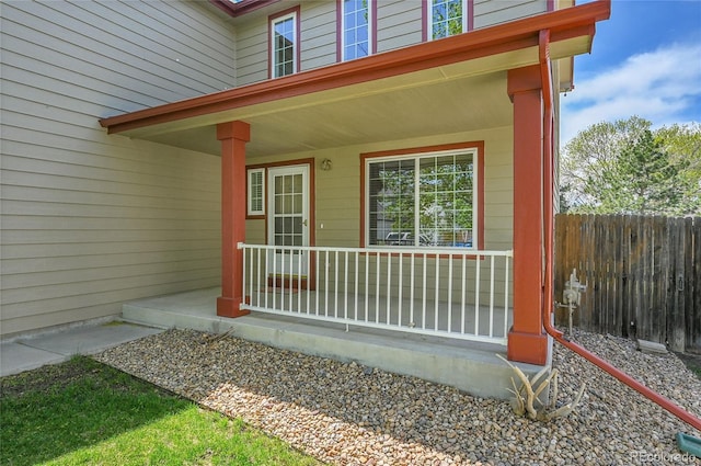 entrance to property featuring fence and a porch