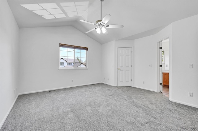 interior space with carpet floors, a ceiling fan, baseboards, and vaulted ceiling