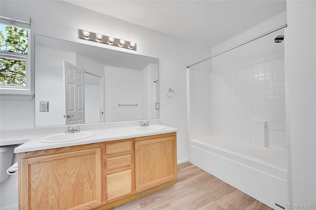 bathroom with a sink, shower / bath combination, double vanity, and wood finished floors