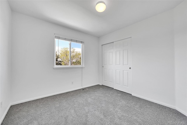 unfurnished bedroom featuring baseboards, carpet, and a closet