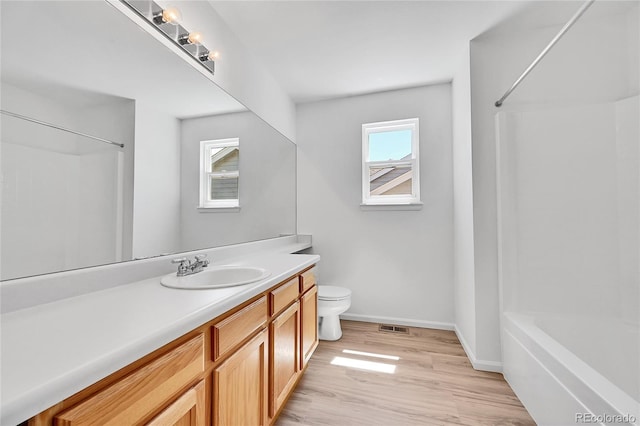 full bath featuring vanity, toilet, baseboards, wood finished floors, and visible vents