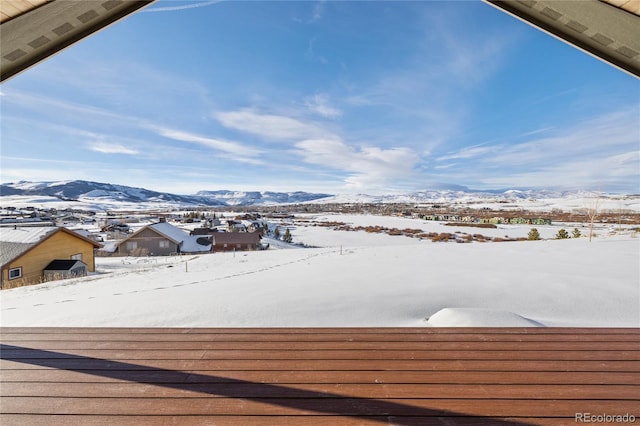 snow covered deck with a mountain view