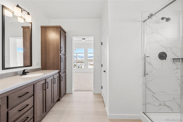 full bathroom with baseboards, crown molding, vanity, and a marble finish shower