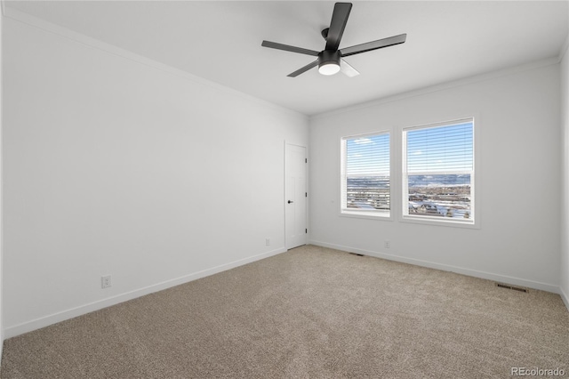 spare room with light colored carpet, ceiling fan, visible vents, and baseboards