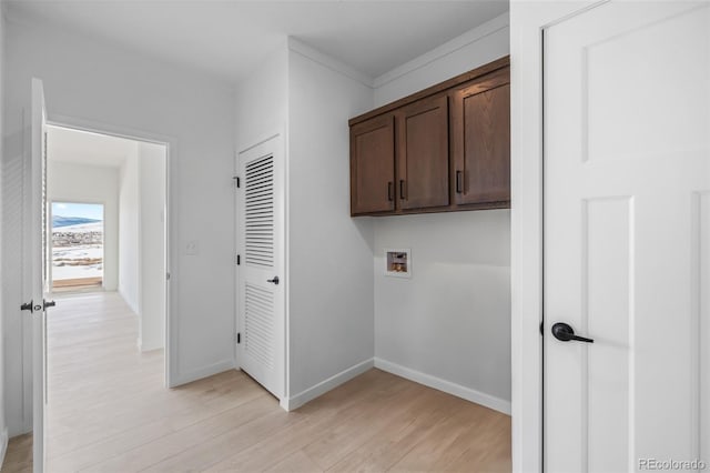 laundry room with hookup for a washing machine, baseboards, cabinet space, and light wood finished floors