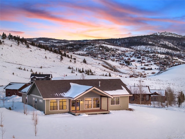 snow covered rear of property featuring a mountain view