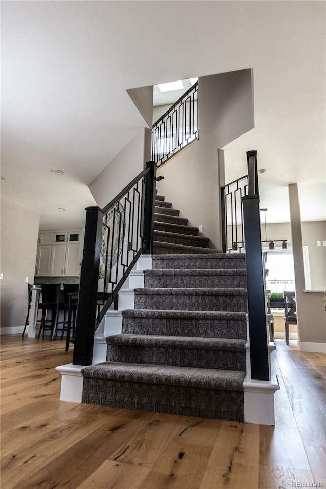 staircase with hardwood / wood-style floors