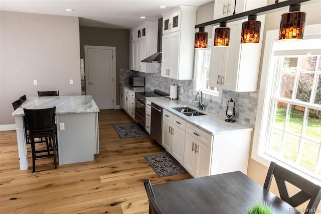 kitchen with a wealth of natural light, white cabinetry, and sink