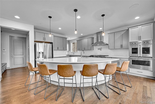 8179 S Kellerman Cir, Aurora, CO 80016 - kitchen featuring wall chimney range hood, appliances with stainless steel finishes, gray cabinets, a sink, and light countertops