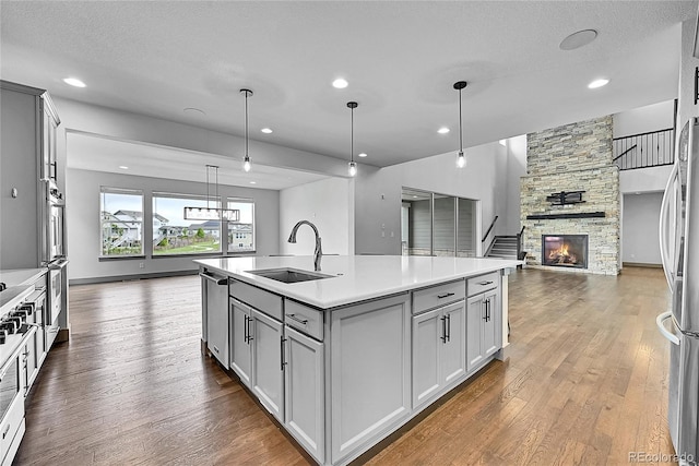 8179 S Kellerman Cir, Aurora, CO 80016 - kitchen featuring open floor plan, a sink, gray cabinetry, dark wood-style flooring, and recessed lighting