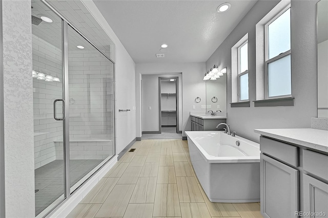 8179 S Kellerman Cir, Aurora, CO 80016 - full bathroom featuring a stall shower, vanity, a freestanding tub, recessed lighting, and baseboards