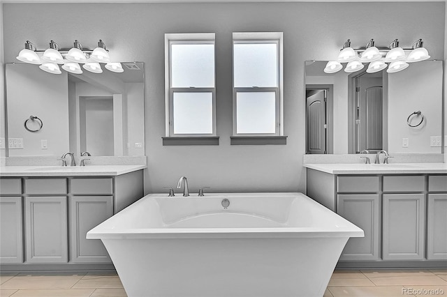8179 S Kellerman Cir, Aurora, CO 80016 - bathroom with two vanities, a freestanding tub, and tile patterned floors