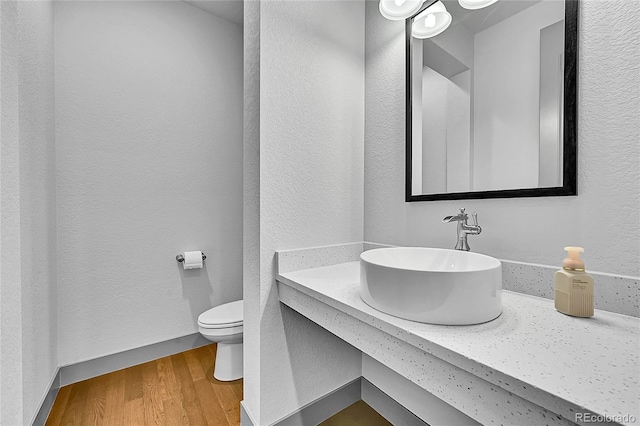 8179 S Kellerman Cir, Aurora, CO 80016 - bathroom featuring toilet, wood finished floors, a textured wall, and vanity
