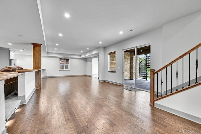 8179 S Kellerman Cir, Aurora, CO 80016 - unfurnished living room with wood finished floors, recessed lighting, stairs, decorative columns, and baseboards