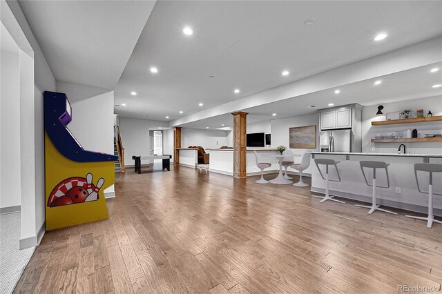 8179 S Kellerman Cir, Aurora, CO 80016 - living area featuring ornate columns, light wood finished floors, recessed lighting, wet bar, and baseboards