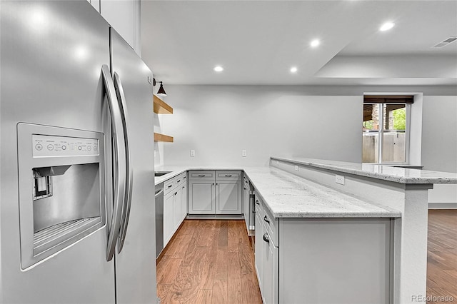 8179 S Kellerman Cir, Aurora, CO 80016 - kitchen featuring stainless steel appliances, open shelves, a peninsula, wood finished floors, and recessed lighting