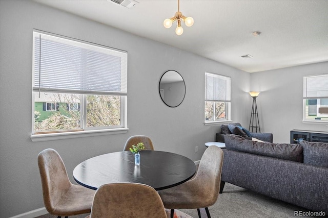 carpeted dining area featuring baseboards, plenty of natural light, and visible vents