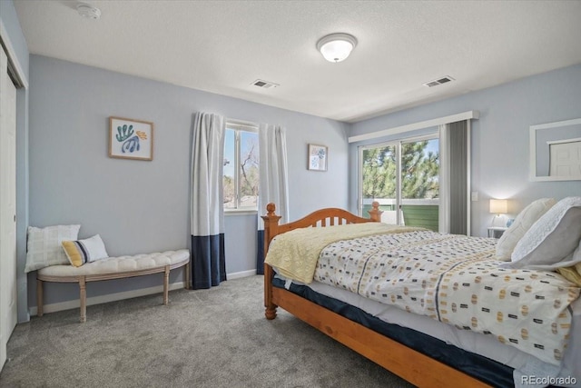 bedroom featuring a textured ceiling, carpet, baseboards, and visible vents