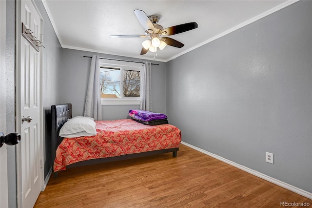 bedroom featuring hardwood / wood-style flooring, ceiling fan, and crown molding